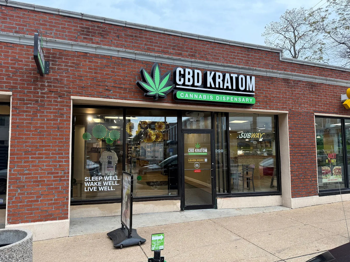 Red brick CBD Kratom storefront on North Euclid Avenue in the Central West End, St. Louis, with a green leaf sign and a window that reads Sleep well. Wake well. Live well.