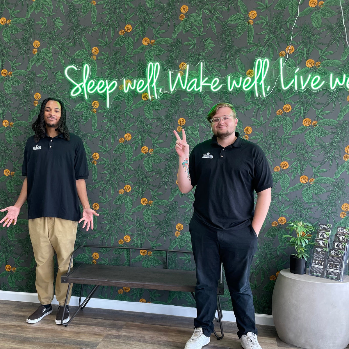 Two CBD Kratom team members in branded polos inside the Cypress store in Houston.
